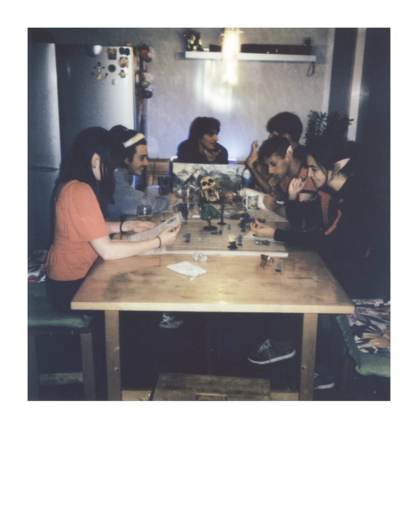 Groep vrienden verzameld rond een tafel om Dungeons & Dragons te spelen, met zichtbare dobbelstenen en speelstukken, wat het sociale en interactieve aspect van het starten van een D&D-spel benadrukt.